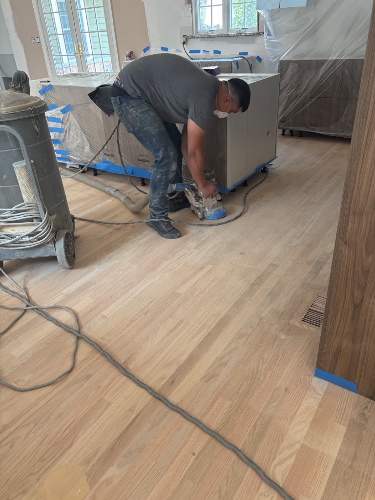 Sterling contractor sanding hardwood floors during refinishing