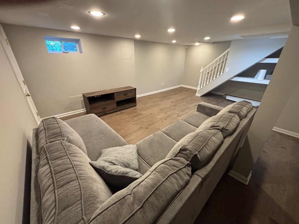 Finished basement with hardwood floors and recessed lighting