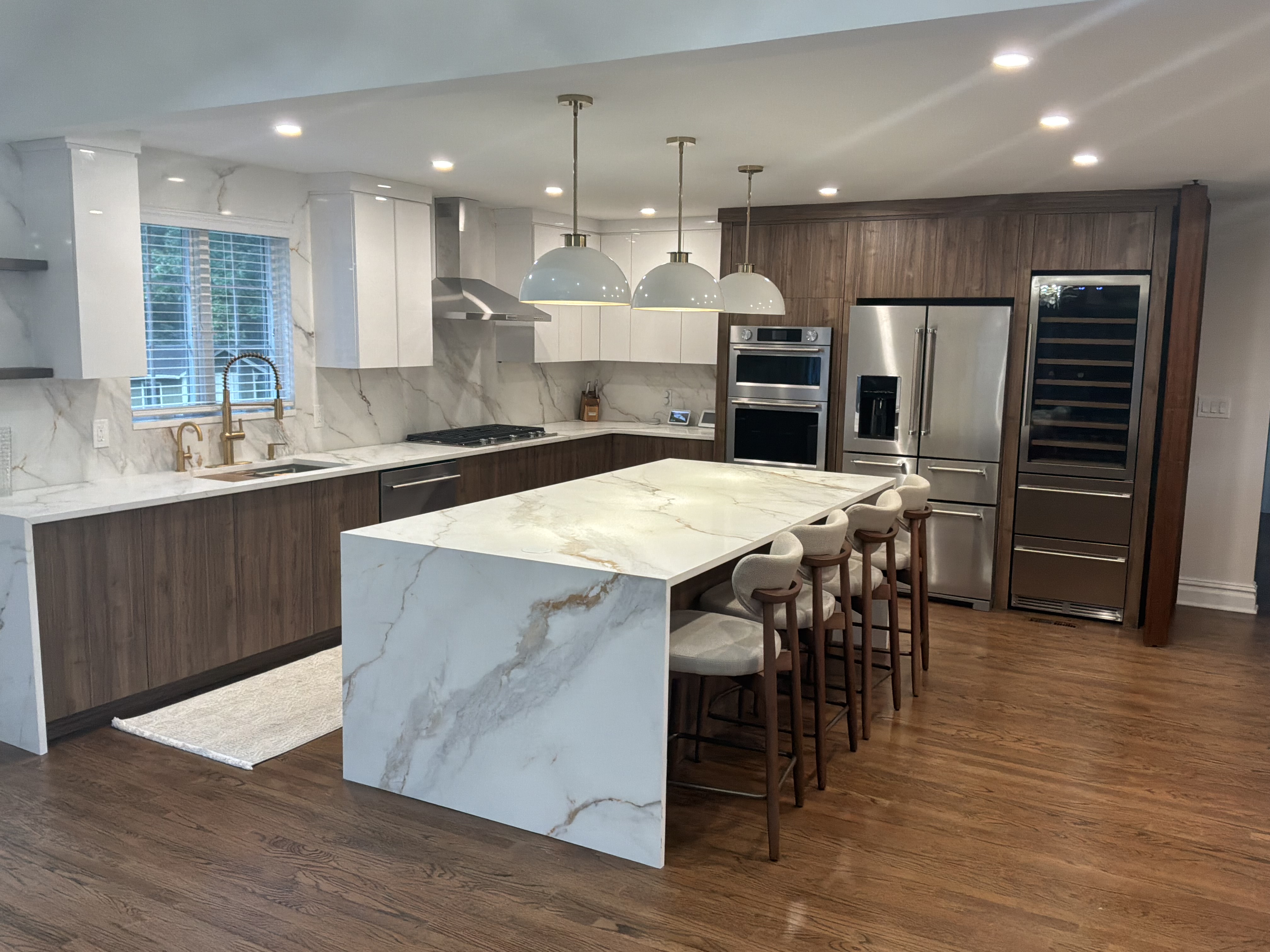 High-end modern kitchen with marble island and wood cabinetry