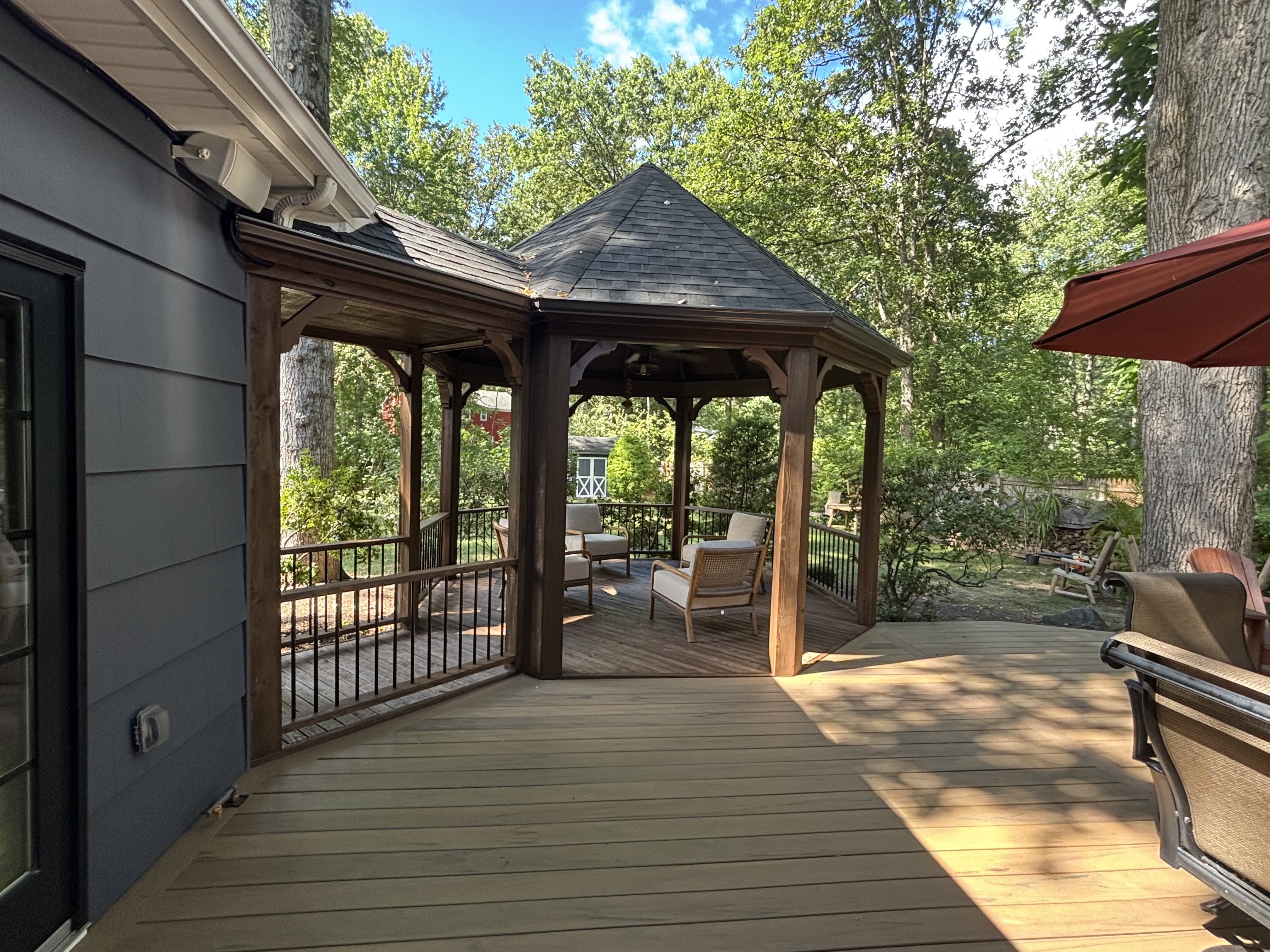 Gazebo with cushioned seating adjoining a composite deck