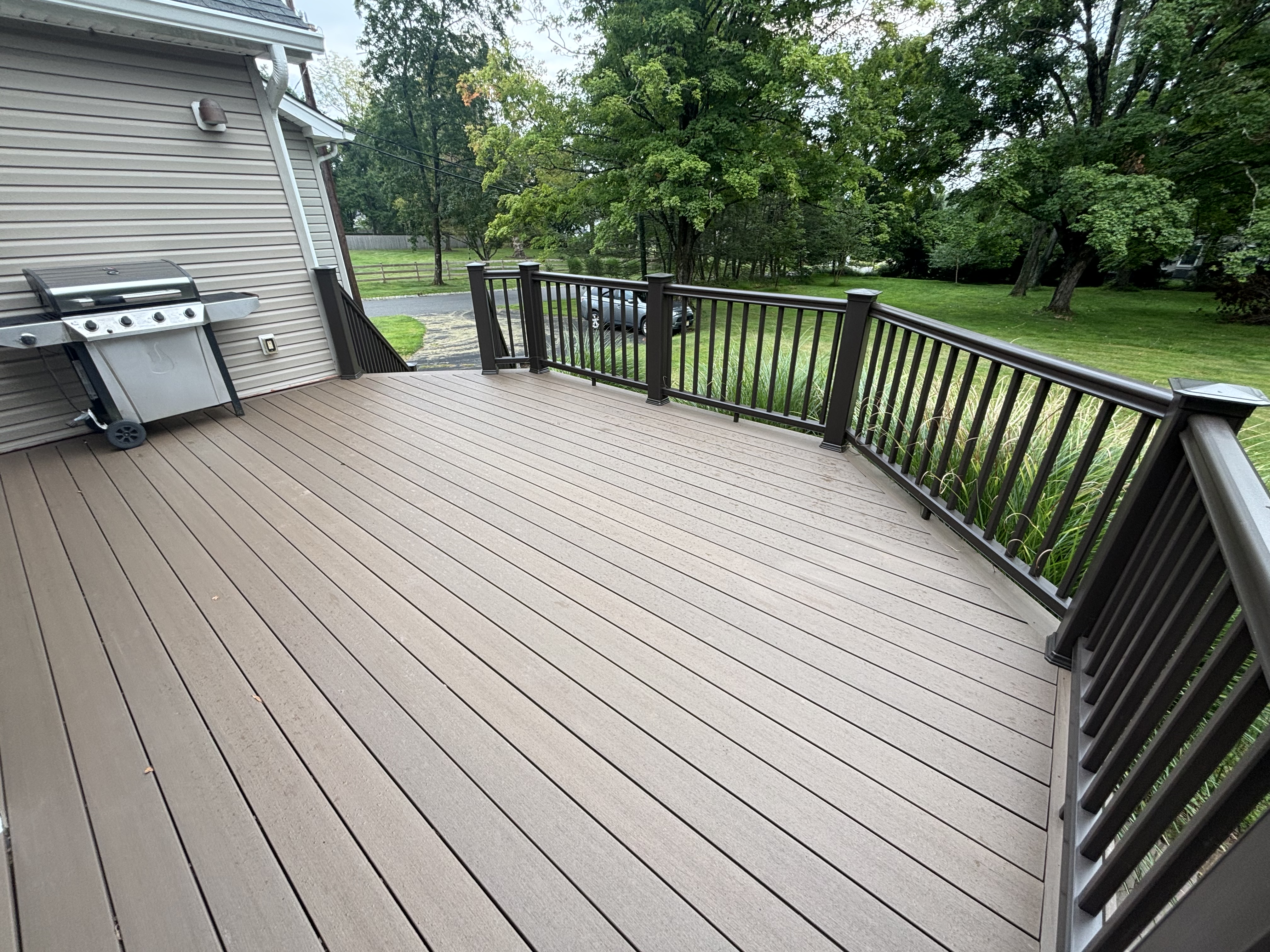 Composite deck with curved railing adjoining the home