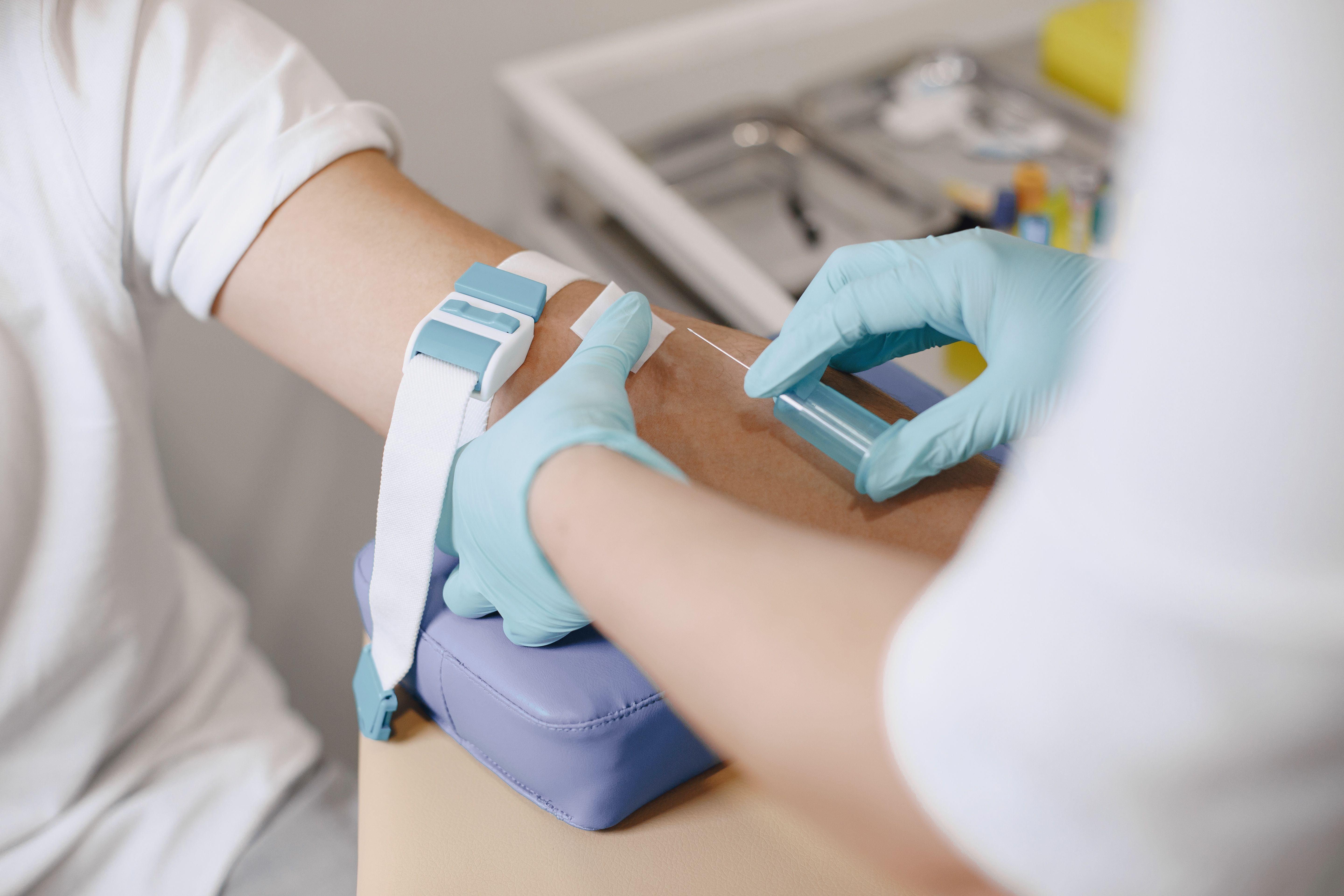 Phlebotomist drawing blood from a patient's arm during an in-office lab visit
