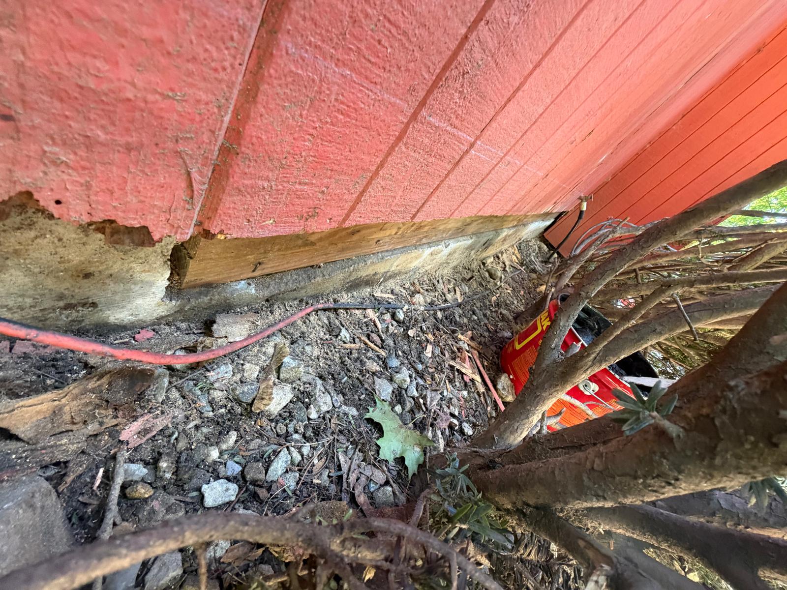 Exterior repair — rotted siding cut out at the foundation line in Hartsdale