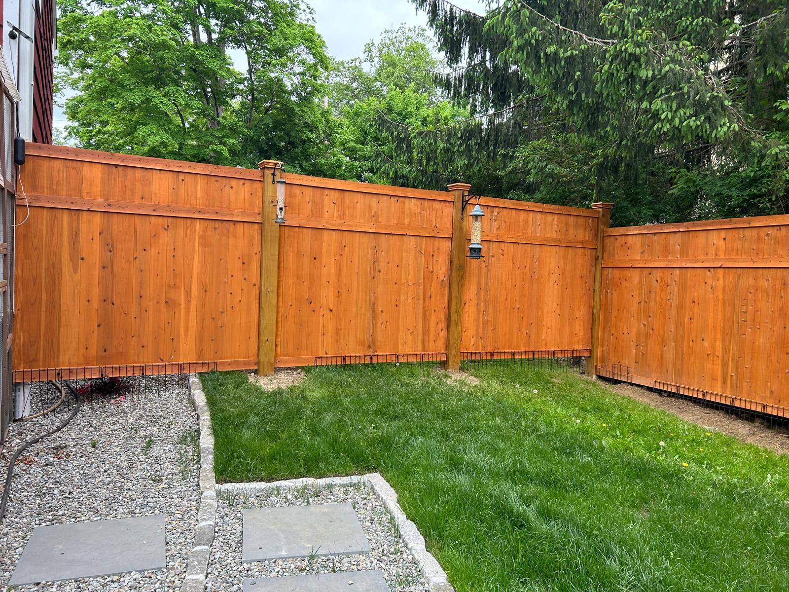 Stained cedar privacy fence along the gravel border in Mount Kisco
