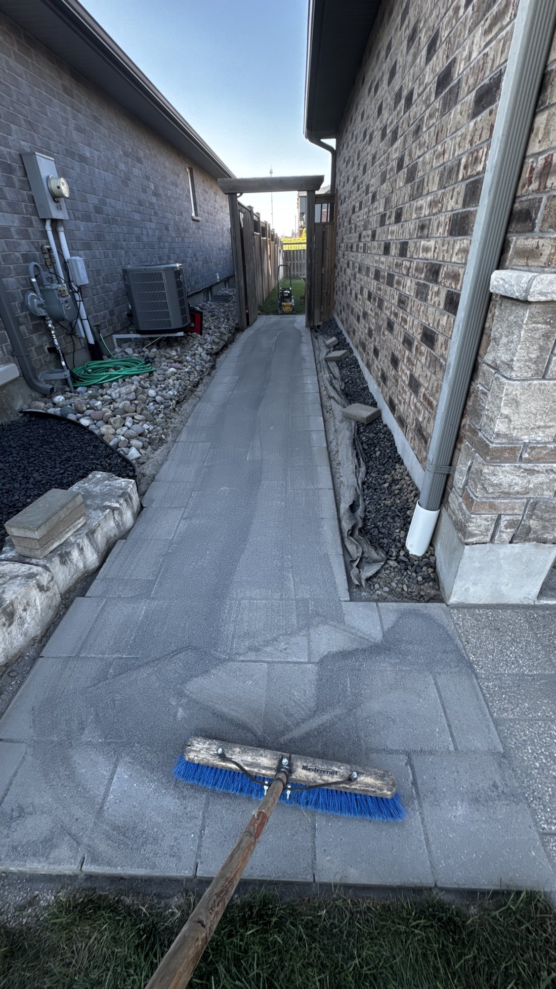 Side yard walkway after — level, clean-laid pavers with drainage beds