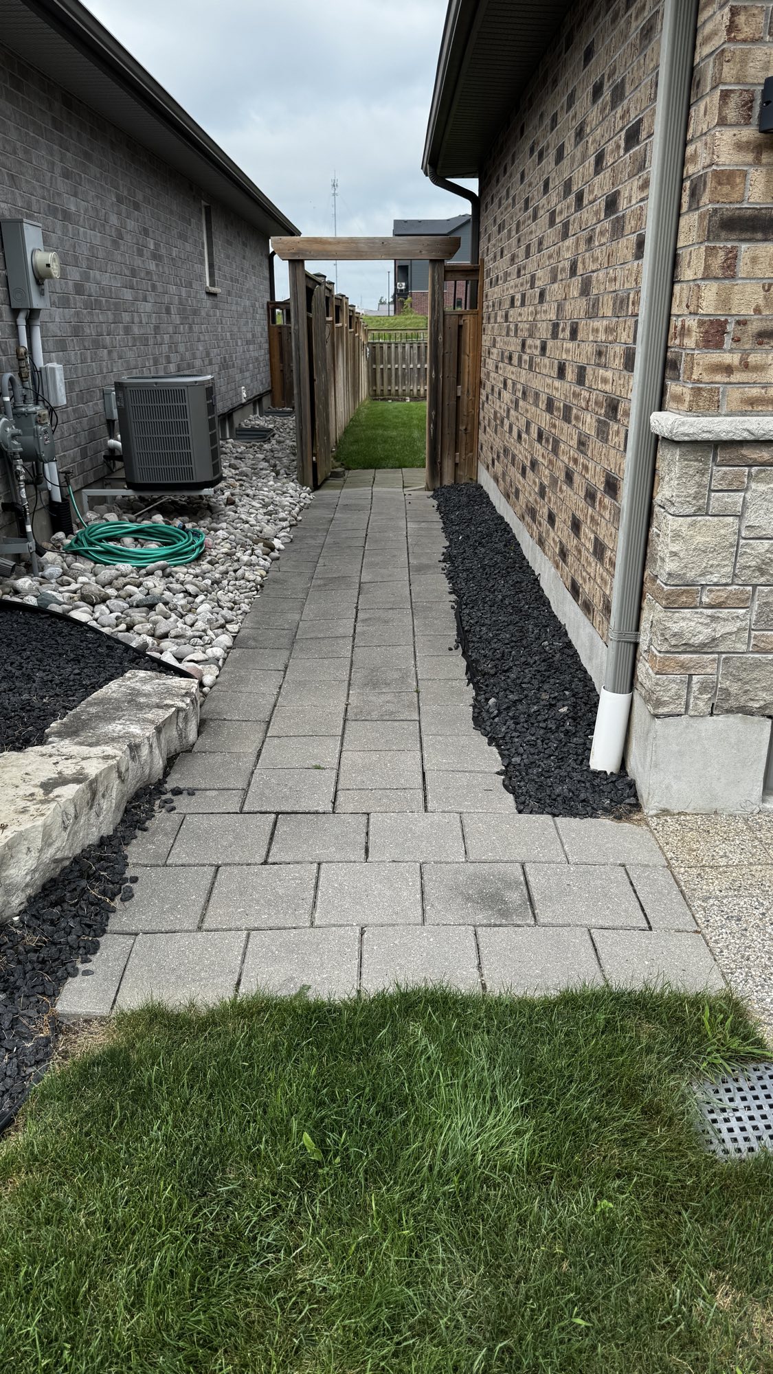 Side yard walkway before — settled, mossy pavers