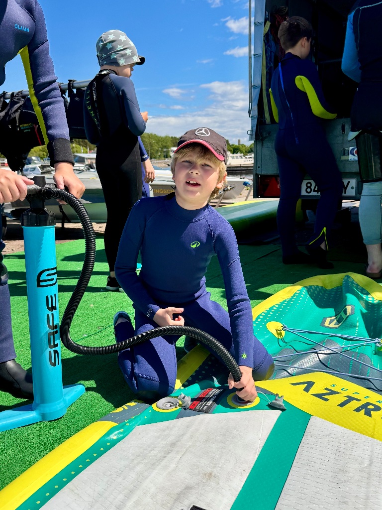 Kids in neoprene wetsuits sailing camp