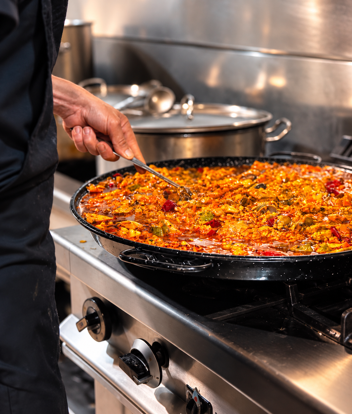 La paella, removida a mano en la cocina