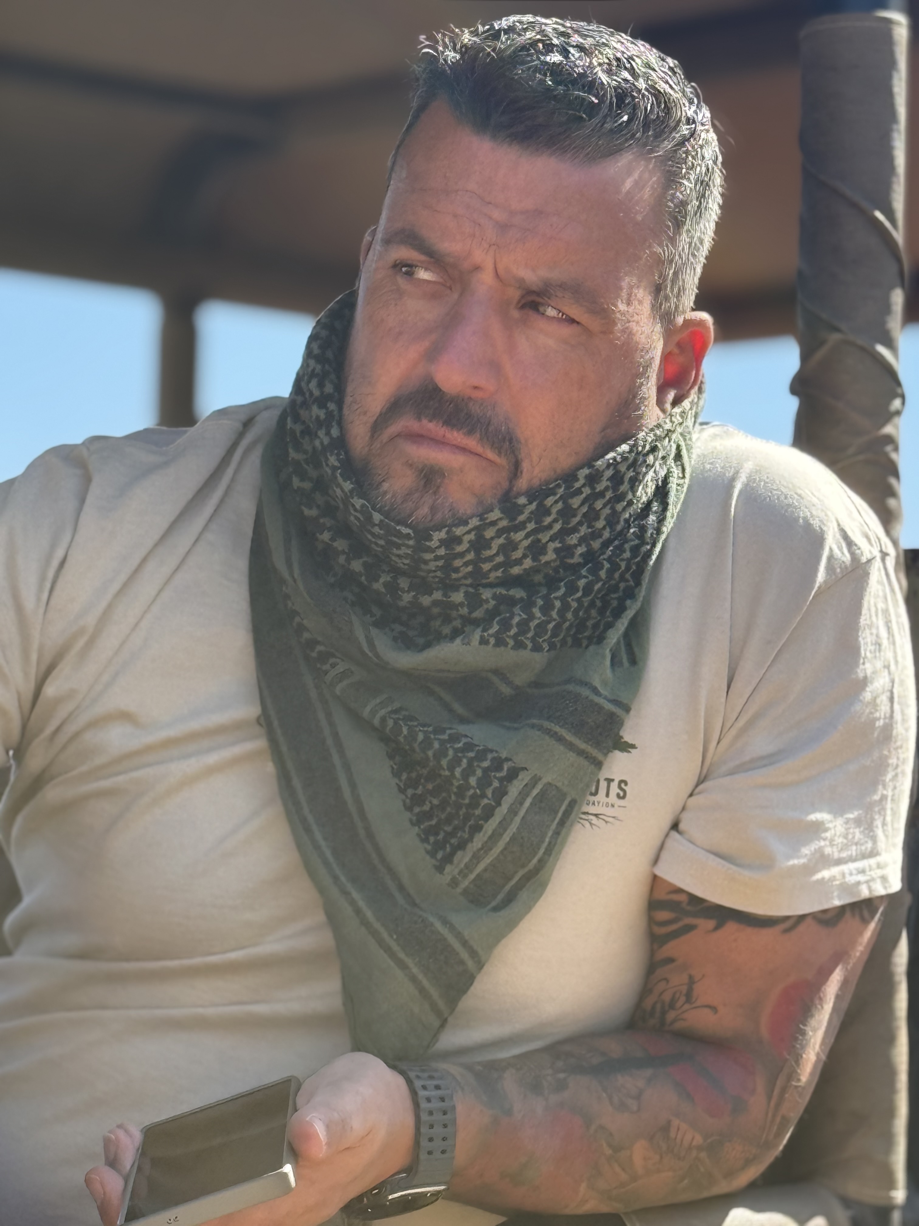 Cohort member in a shemagh aboard the safari vehicle