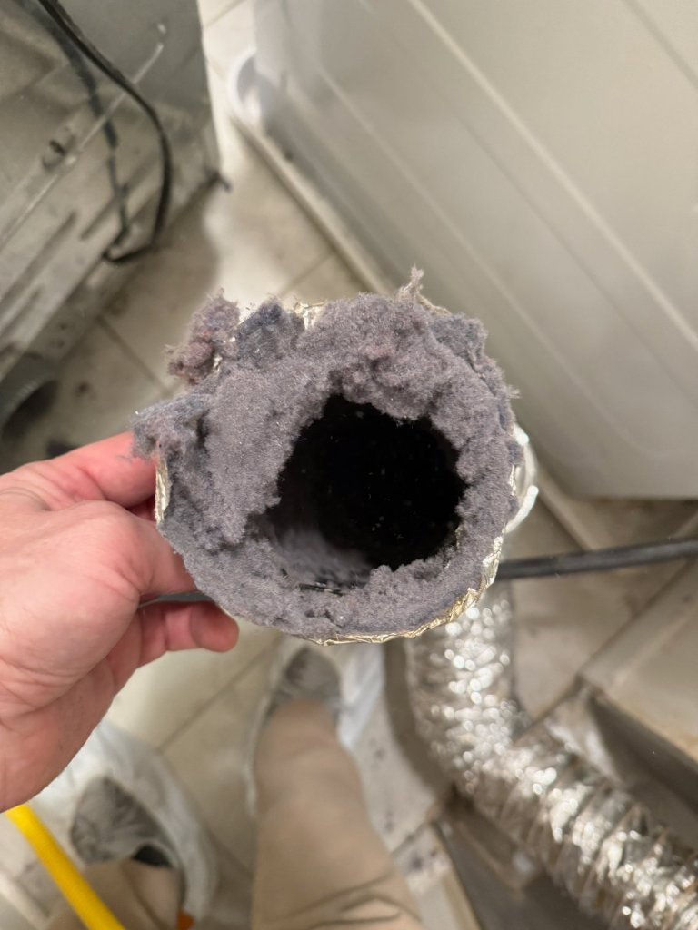Dryer duct before cleaning — heavy lint buildup