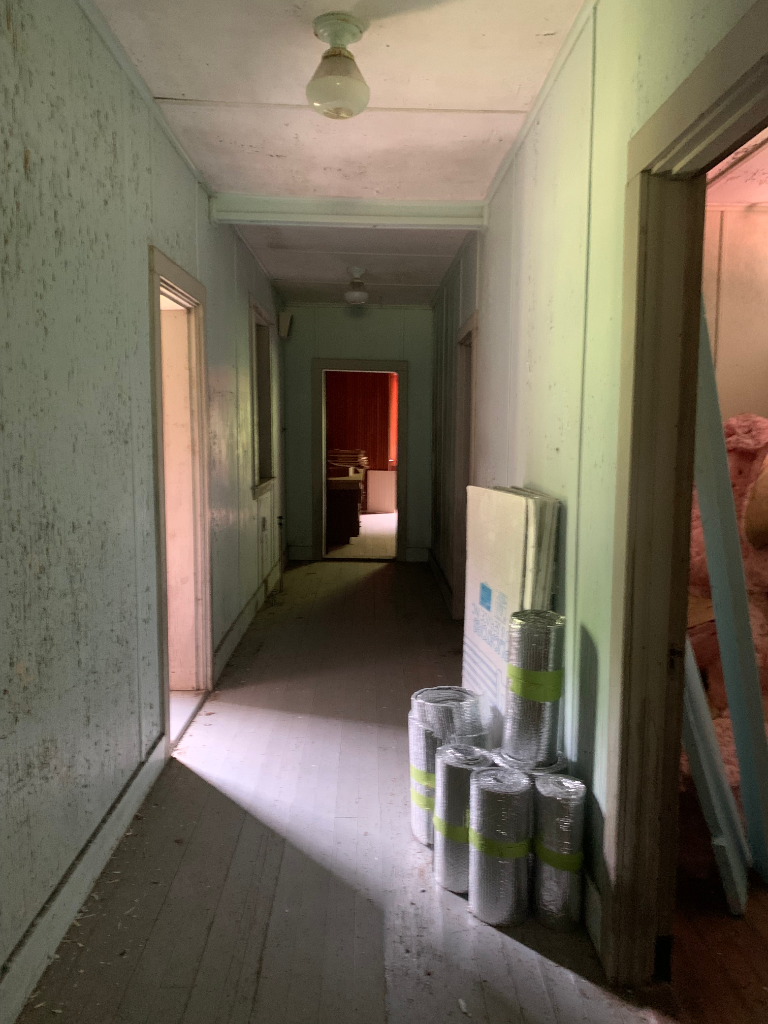Dim interior hallway of the barn with mint-green paneled walls