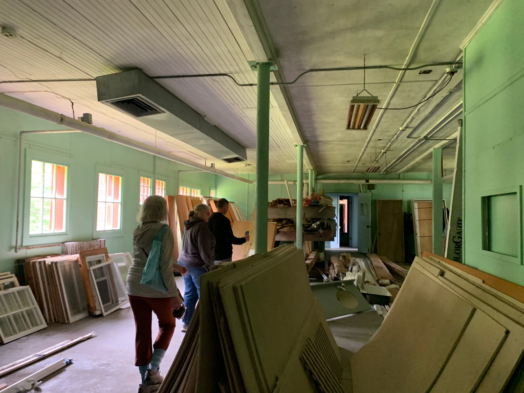 Interior of barn being evaluated for adaptive reuse, cluttered with materials