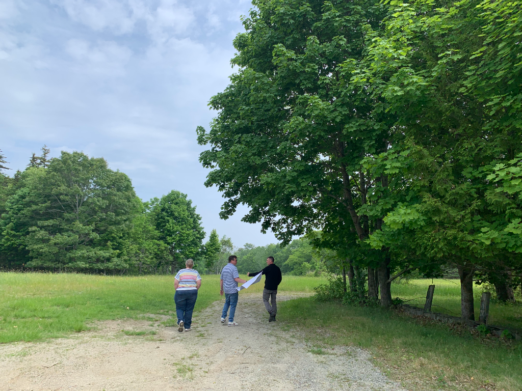Site review team walking the gravel path toward the barn, Hamilton Station