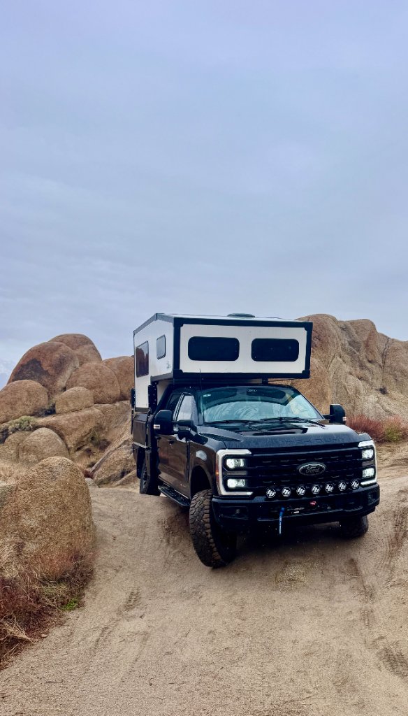 Bison Overland flatbed truck camper in mountain terrain
