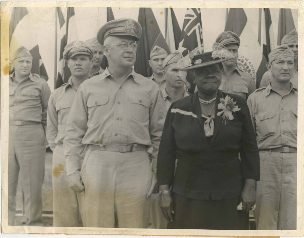 Dr. Mary McLeod Bethune stands with Secretary of War Henry L. Stimson and military personnel, 1941.