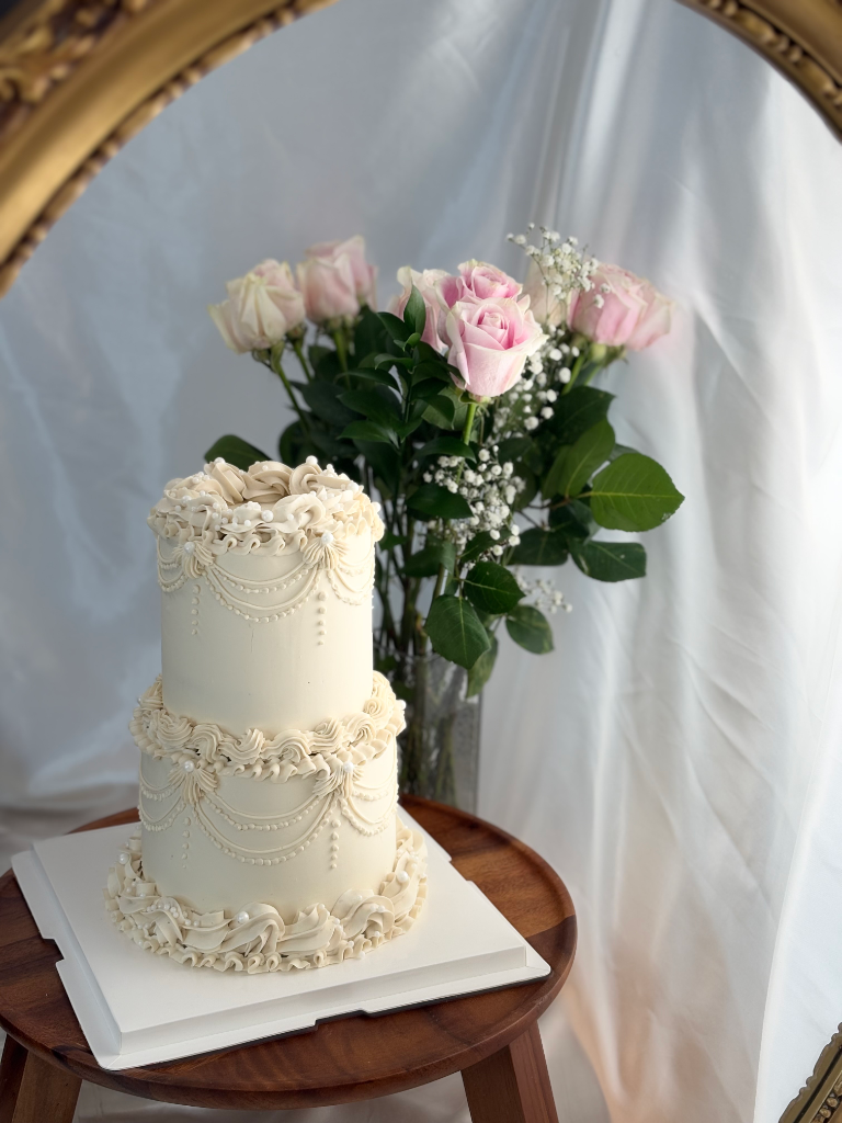 Gâteau de mariage deux étages crème piping baroque roses fraîches — Délices Éthérés