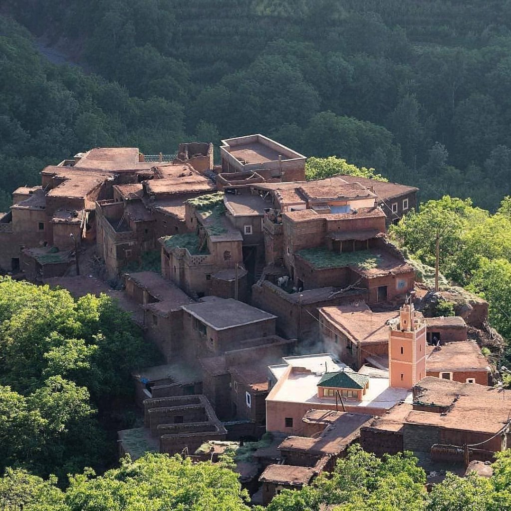 An overview of Imlil village and its mosque minaret surrounded by green trees