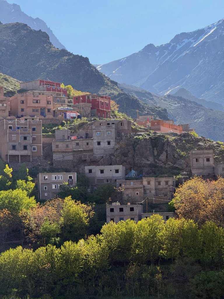 Imlil village set against snow-capped High Atlas peaks among autumn foliage