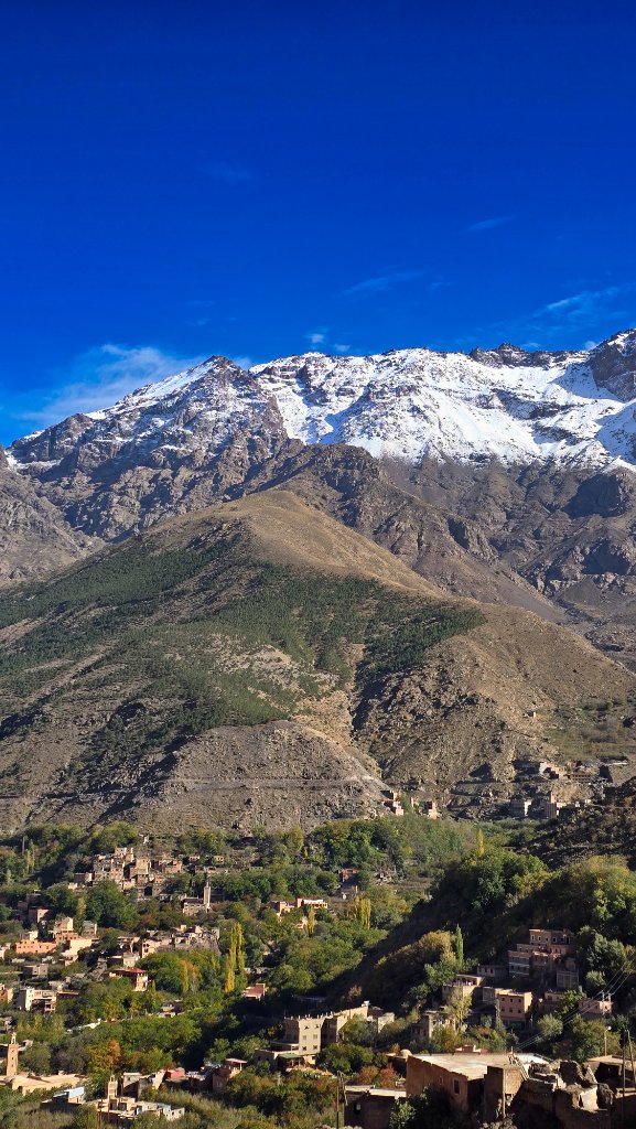 Panoramic view of Imlil village in the High Atlas Mountains under a clear blue sky with snow-capped peaks