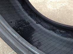 Looking into a tyre casing showing a build-up of pulverized black rubber debris on the inner liner from run-flat damage.