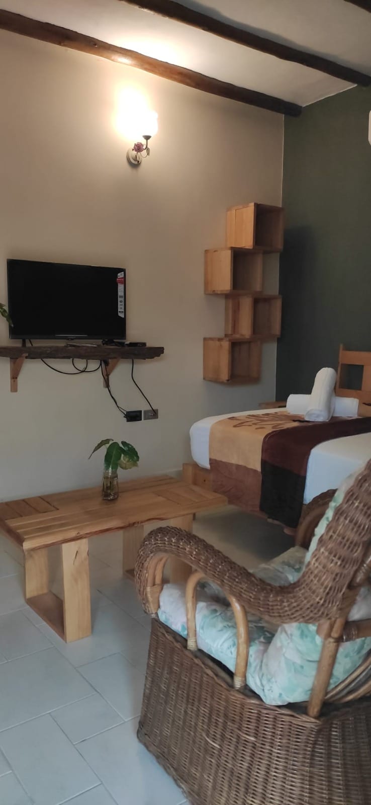 Rincón de la habitación con silla de mimbre y detalles rústicos