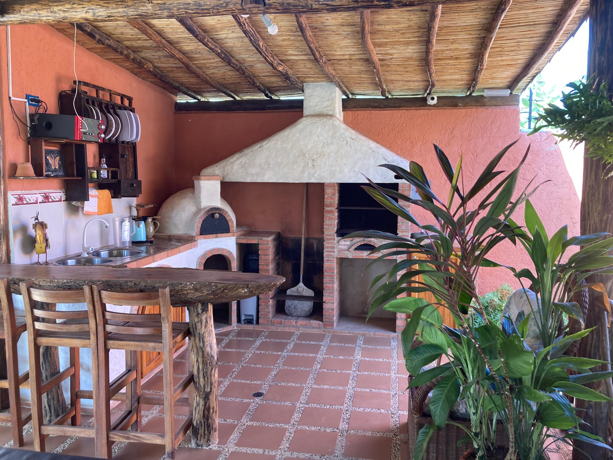 Cocina exterior con horno de leña y parrillera