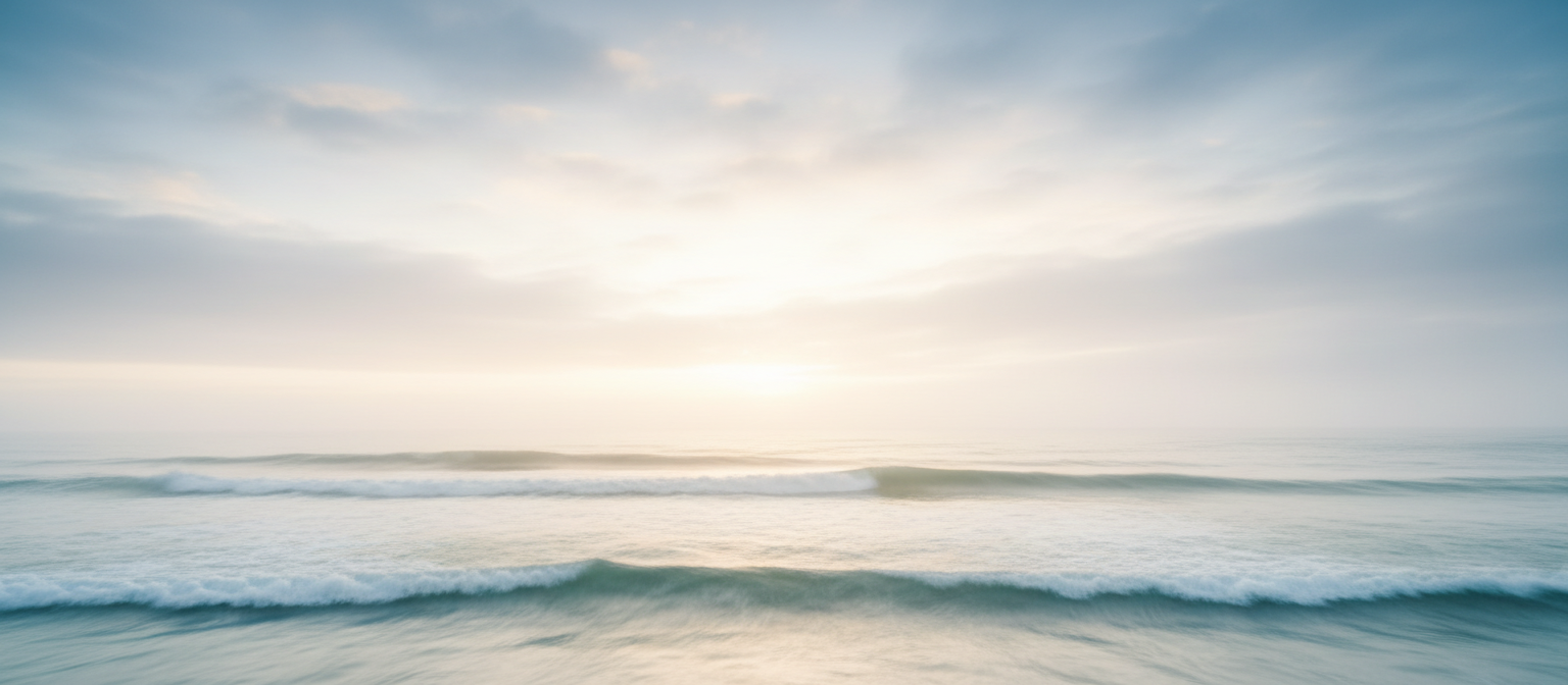 Calm ocean meeting a foggy sky at golden hour