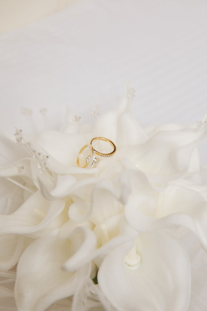 Two gold bands nestled into a handmade calla lily by MoreThanFlowrs.