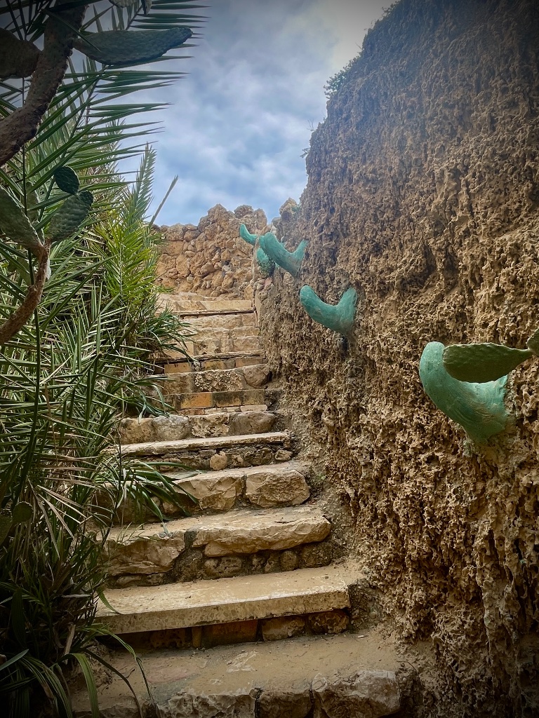 Stone pathway with green sculptures