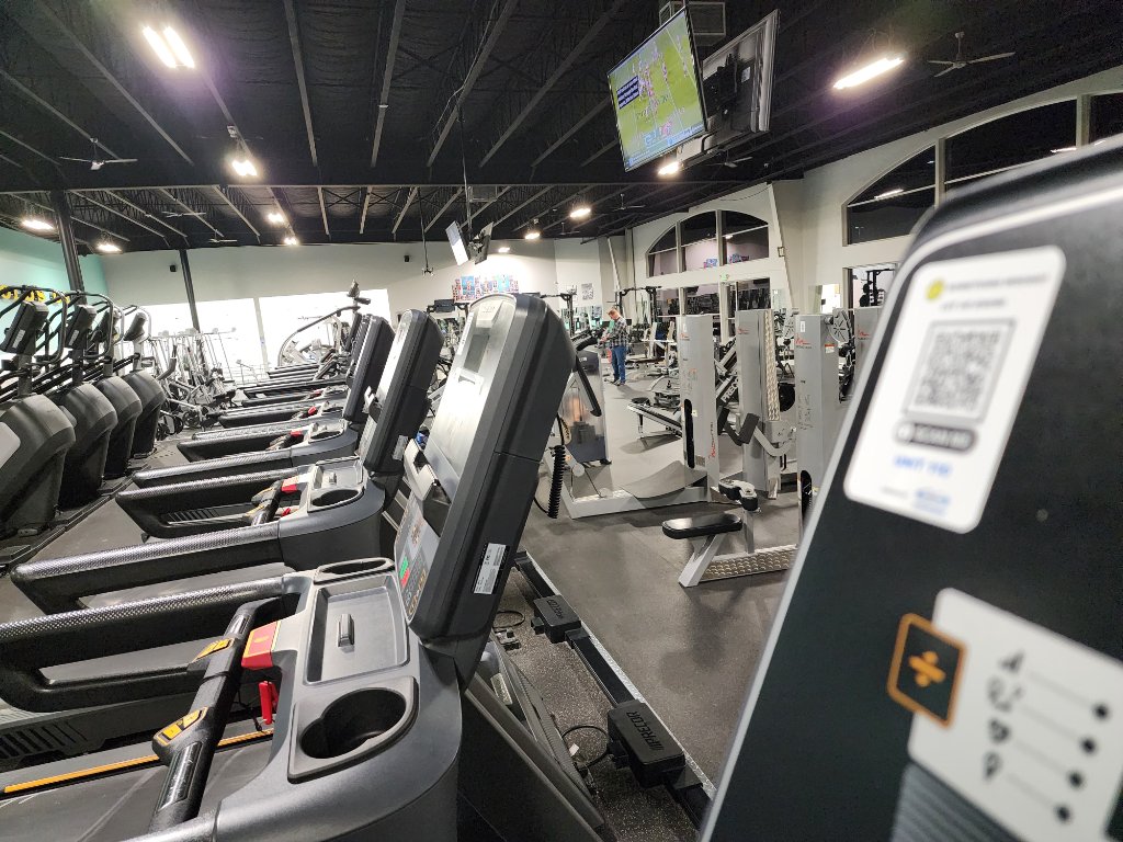 Gym floor with QR code asset tracking tags on equipment