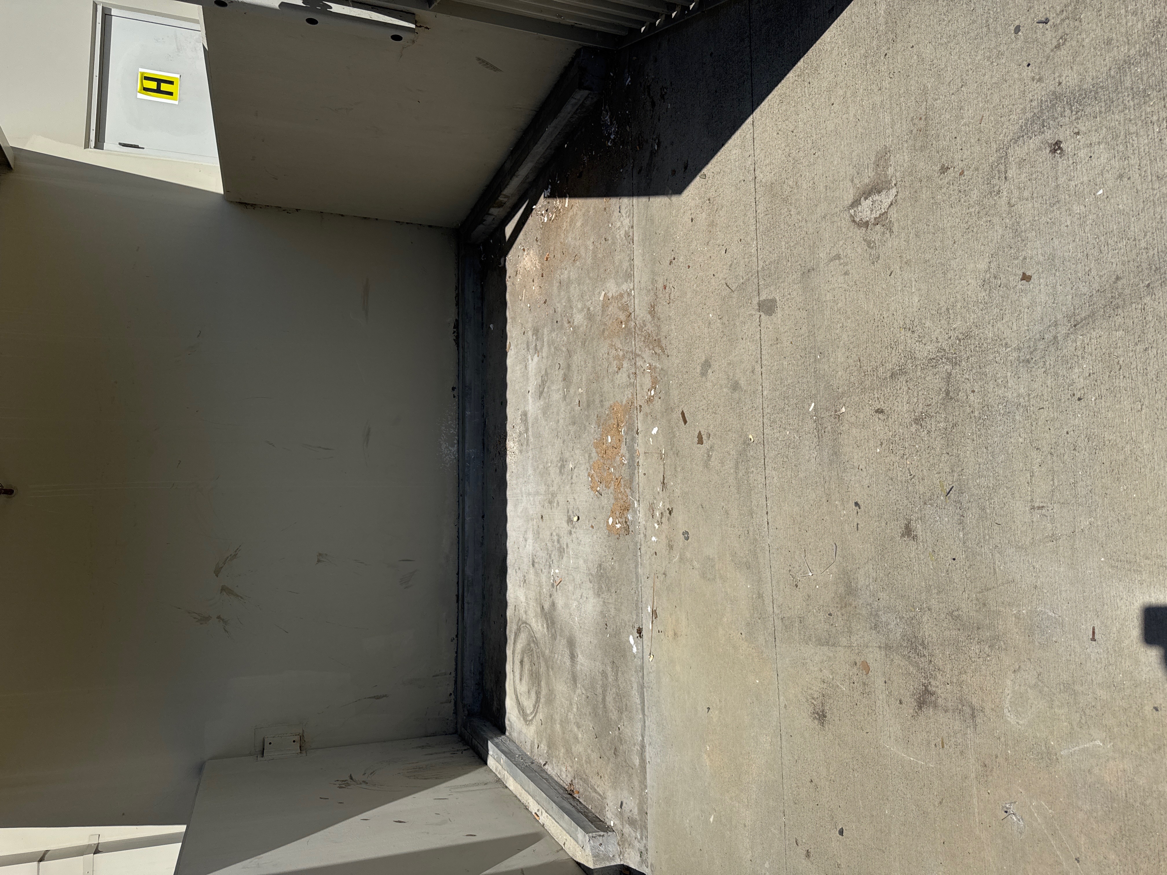 Dumped cardboard boxes and debris against a metal wall - after cleanup