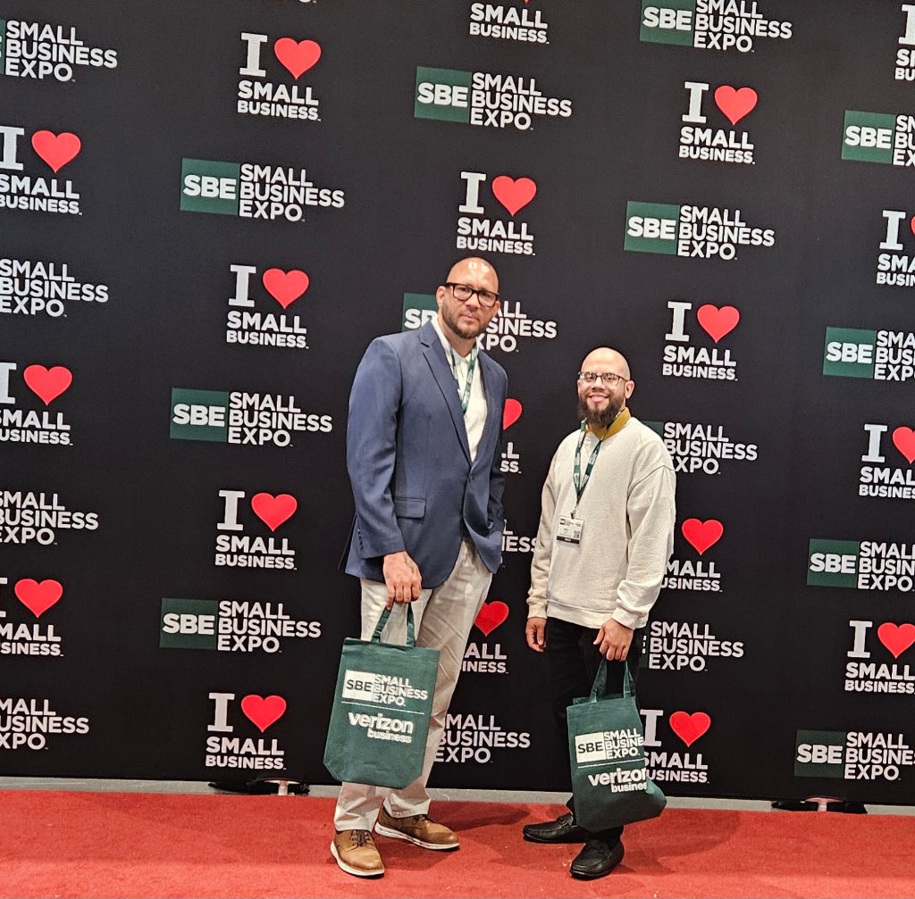 NJTECHLAND LLC team members at Small Business Expo New York City 2026 in front of SBE step-and-repeat backdrop with Verizon Business bags