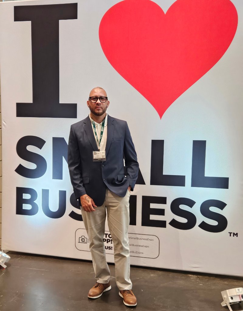 NJTECHLAND LLC representative at Small Business Expo New York City Spring 2026 standing in front of I Love Small Business backdrop