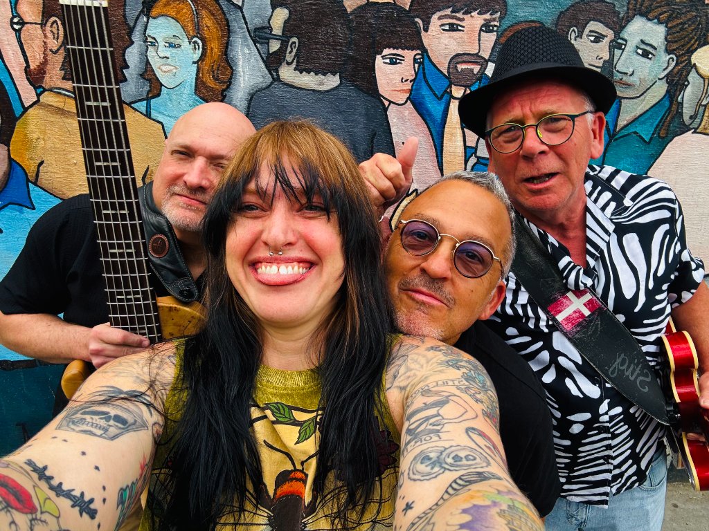 Band at mural with sign