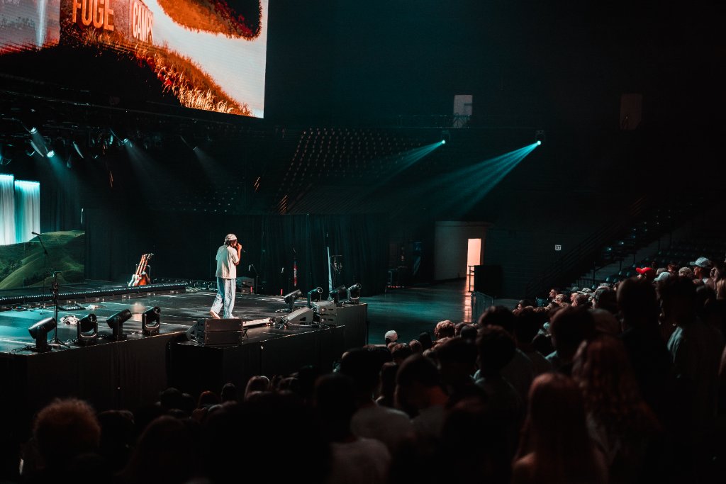 Soul Hemingway on stage with teal spotlights at the Vines Center