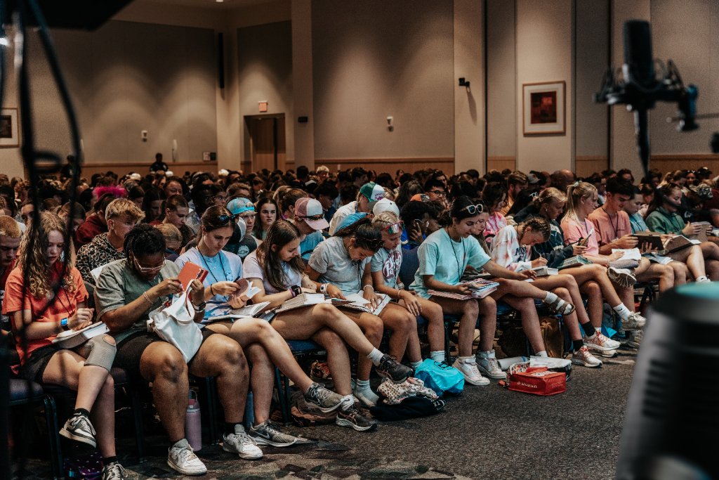 Students taking notes and reading Bibles at FUGE Camps JMU