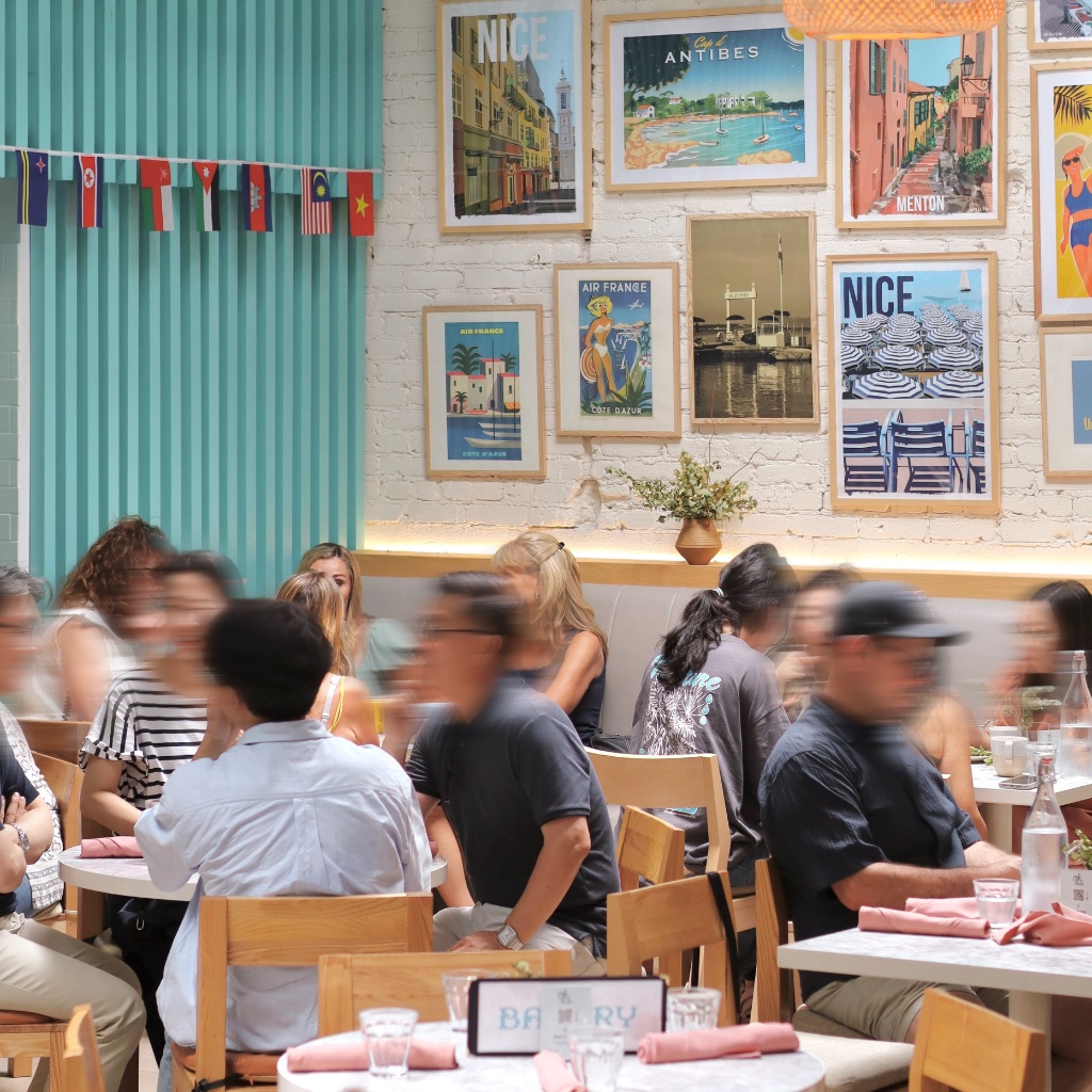 OHLALA Bakery dining room with teal ribbed wall and vintage travel posters