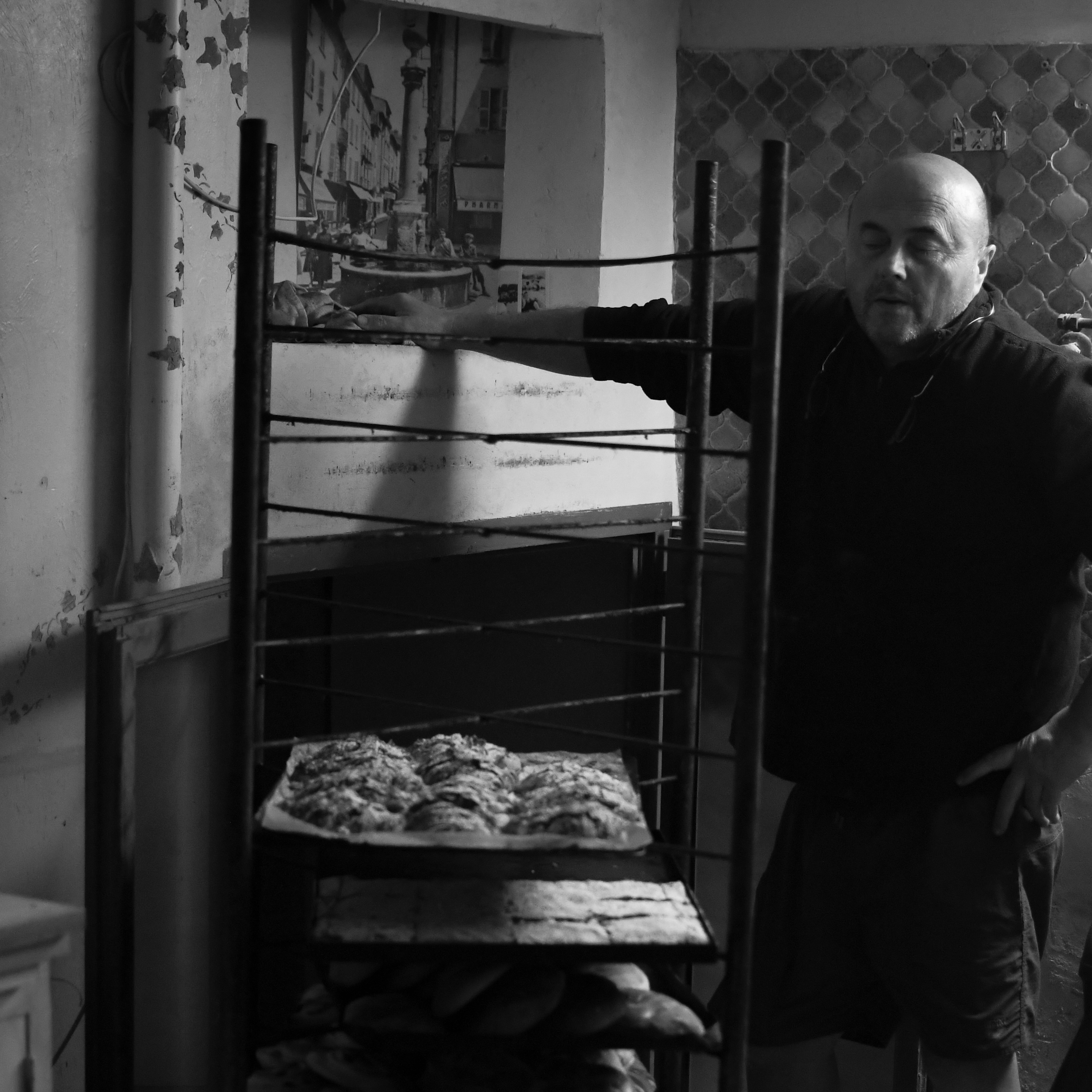 Baker in the bakery beside a rack of pastries