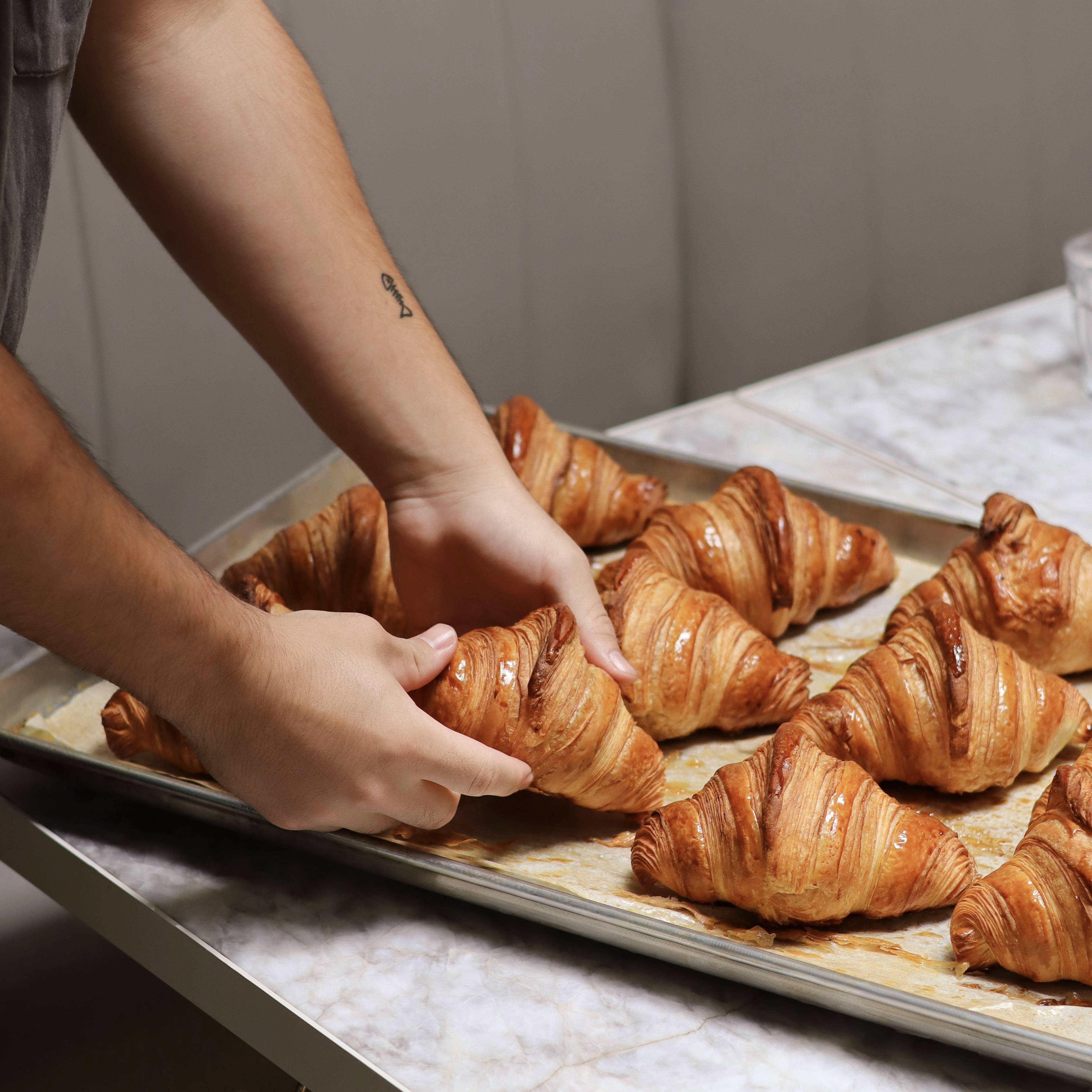 Freshly baked golden croissants on a baking sheet