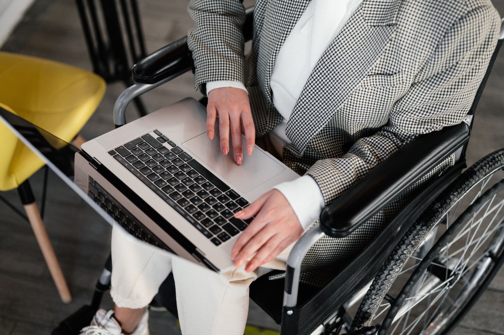 Osoba z niepełnosprawnością przy laptopie