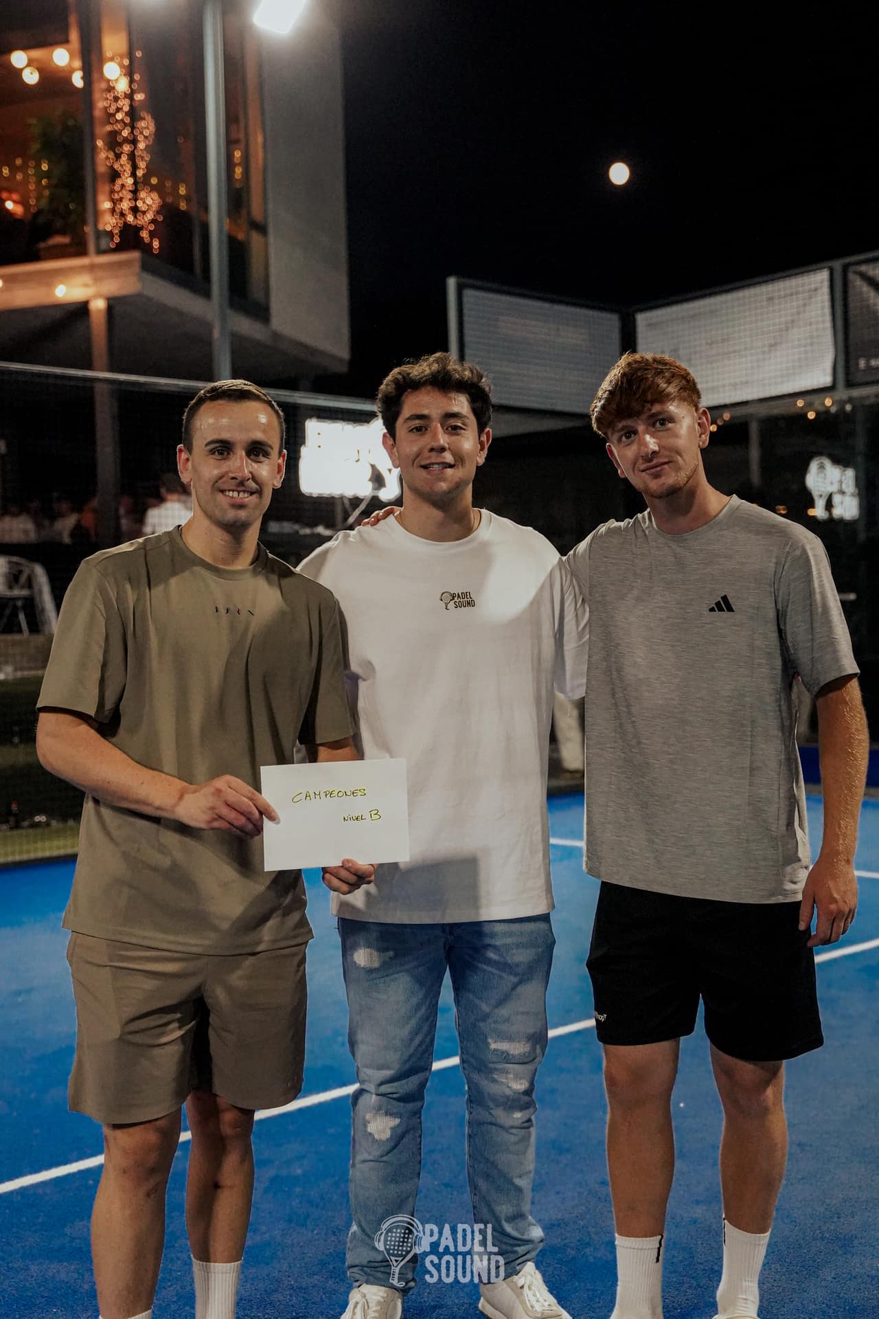 Campeones Categoría B Edición 005 de Padel Sound posando en la pista central de noche