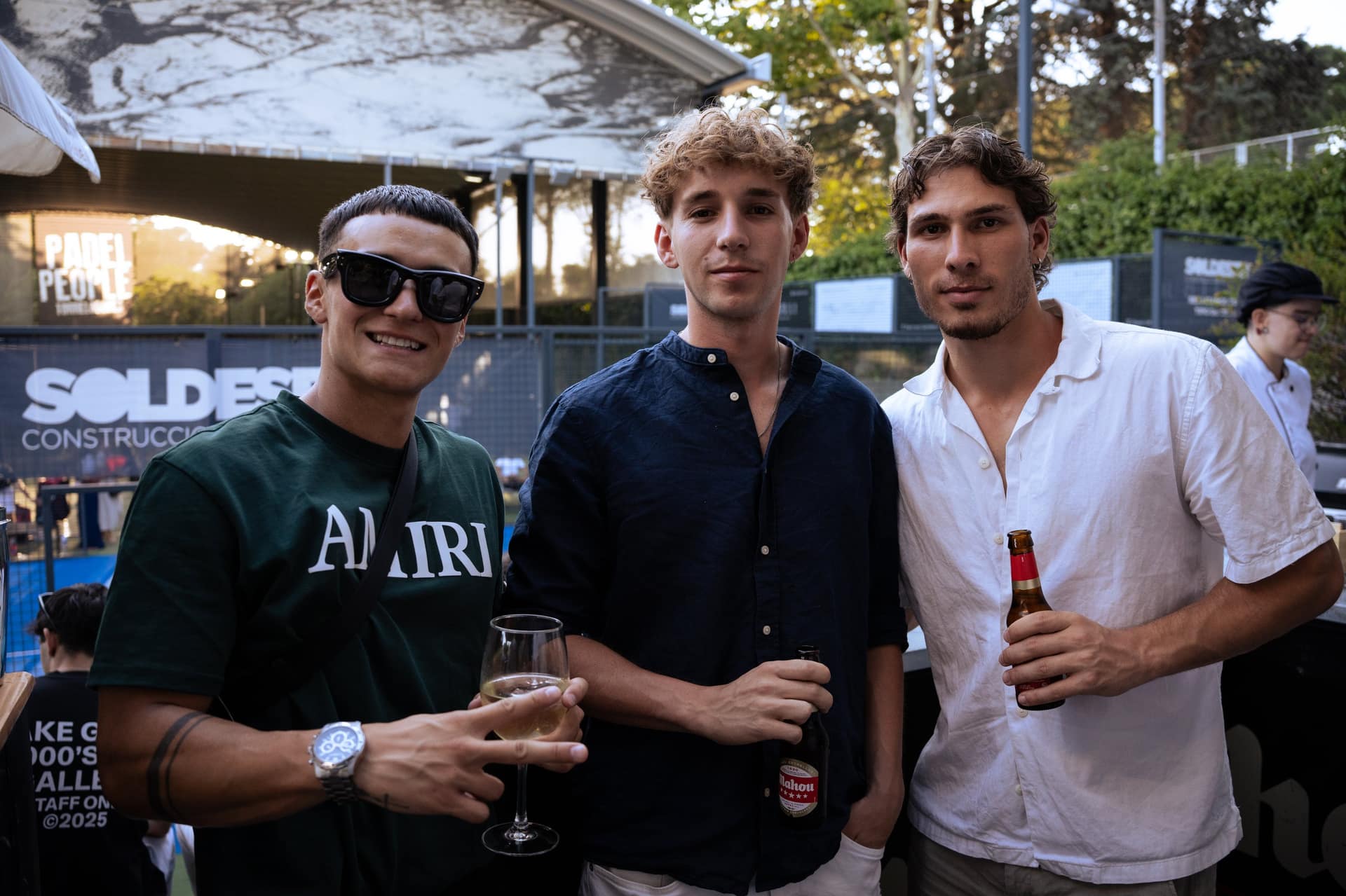 Tres jugadores posando con cerveza en las instalaciones de Padel Sound 005 al atardecer