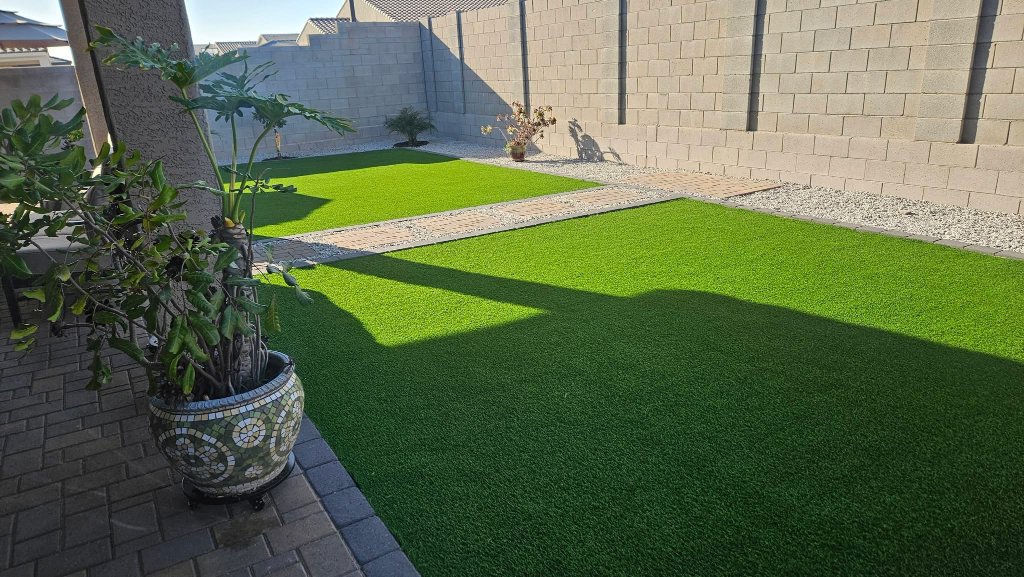 Artificial turf backyard with paver walkway and gravel