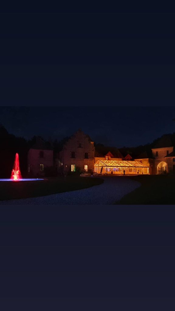 Chapiteau cristal illuminé de nuit devant château