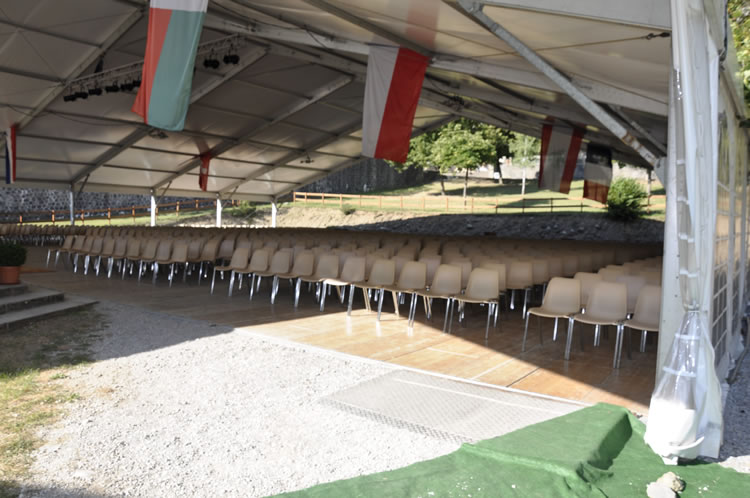 Rangées de chaises sous structure 30m avec drapeaux pour pèlerinage