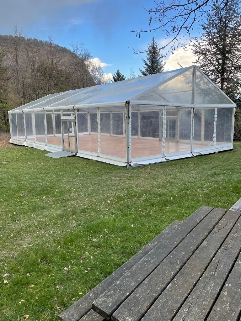 Structure 10x15 avec toits et murs cristal dans un parc
