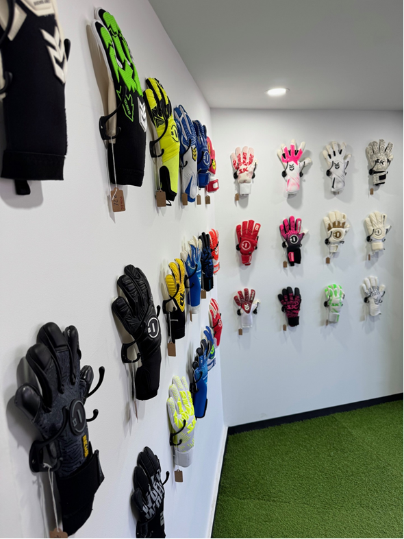 Pared de guantes de portero expuestos en la tienda El Hogar del Portero