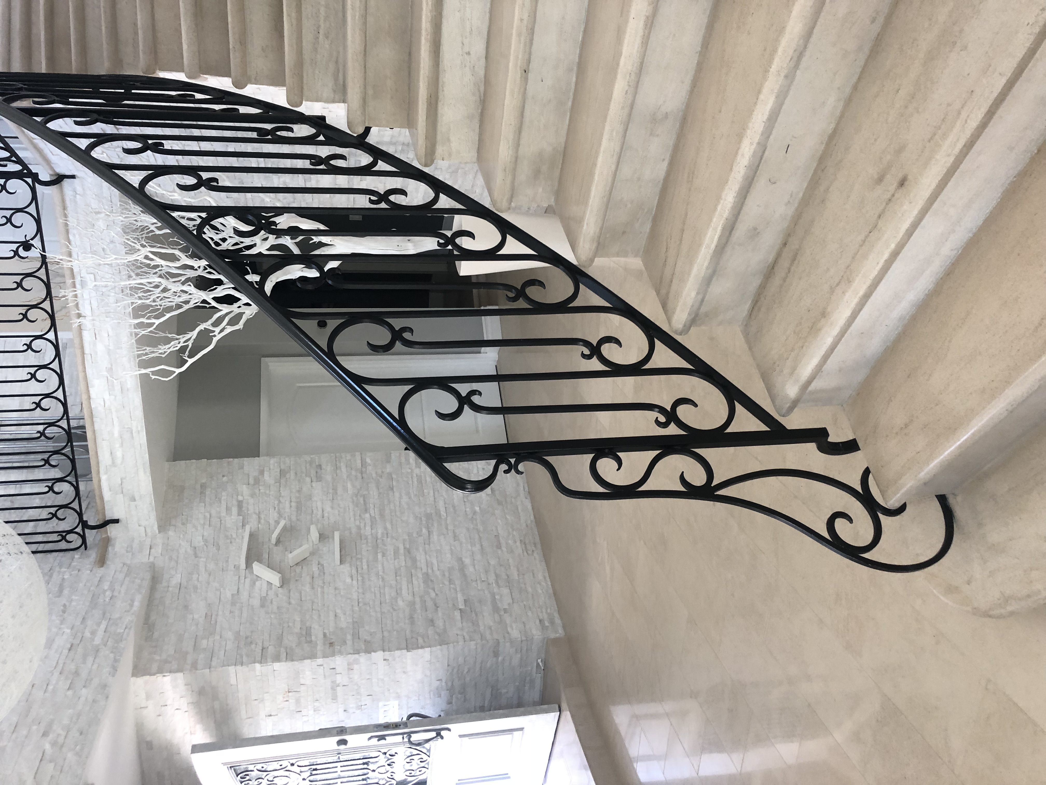 Curved Stone Staircase with Scrollwork Railing