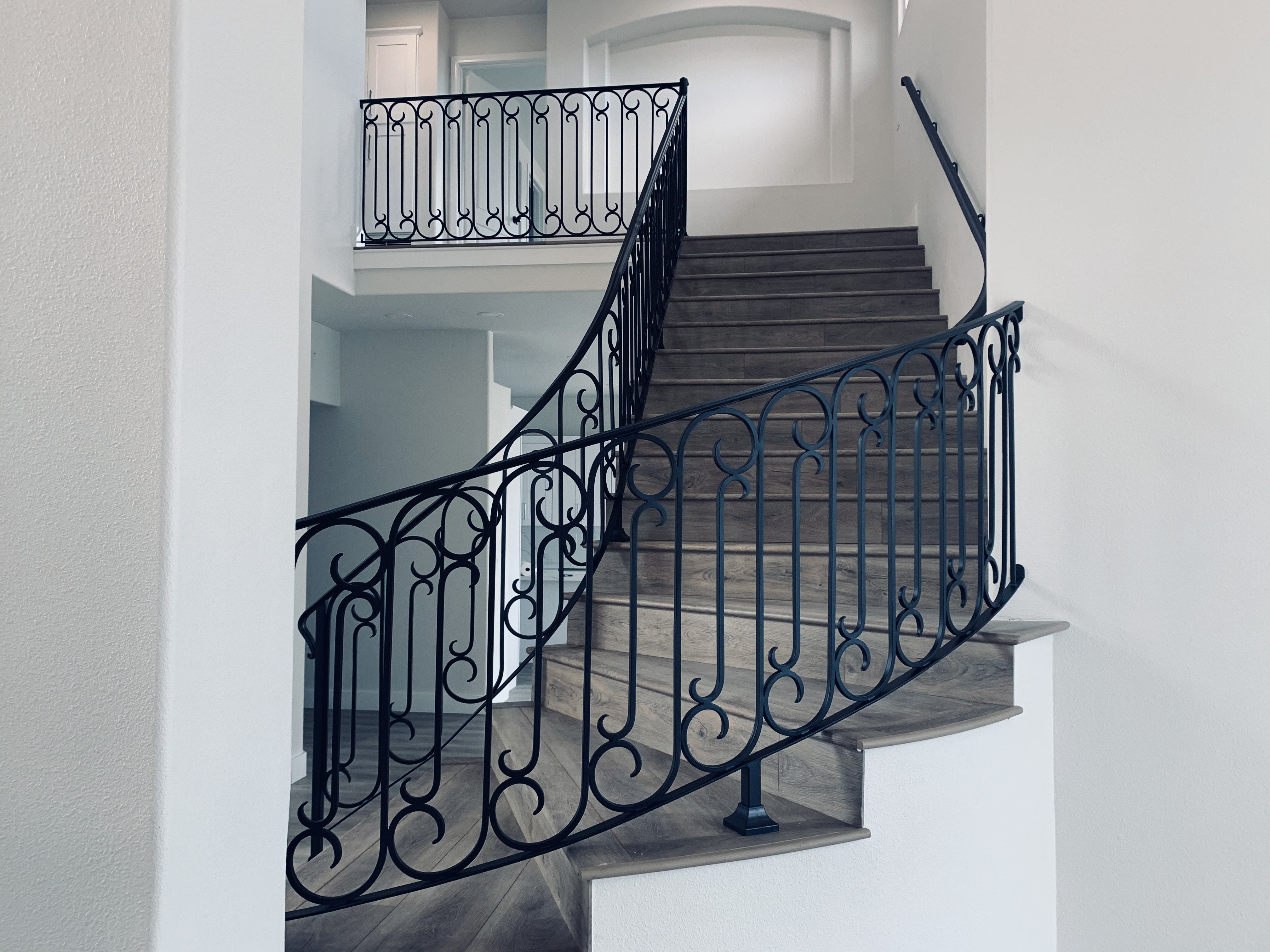 Curved Scrollwork Staircase with Oval Baluster Railing
