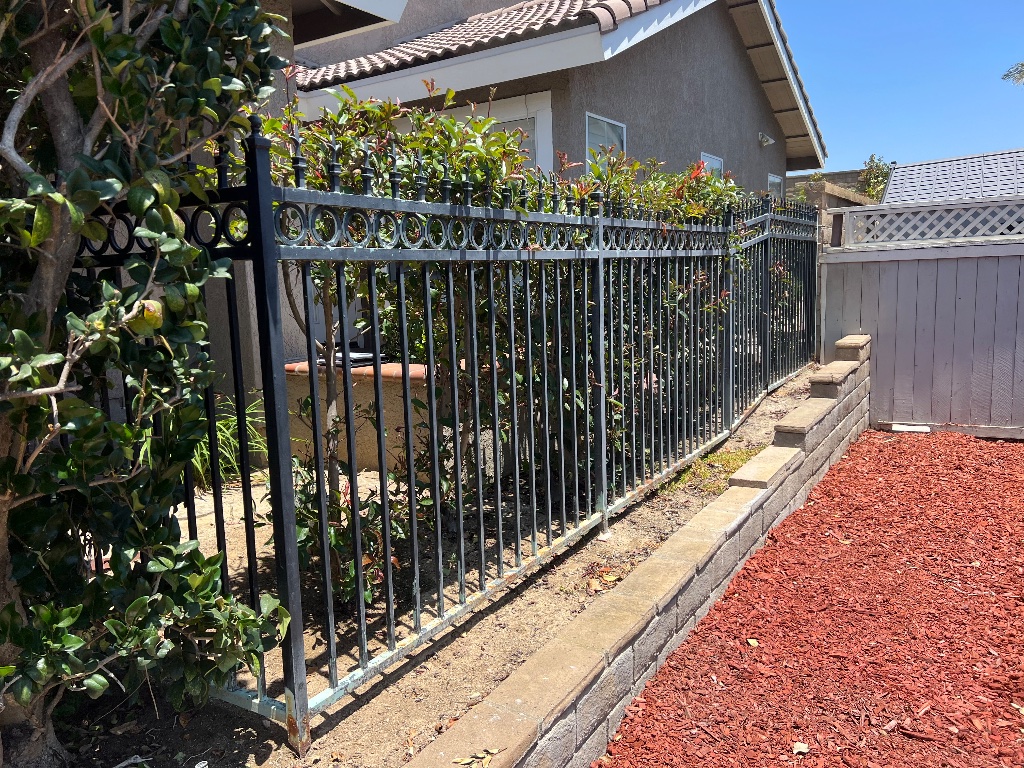 Rusted black metal picket fence in Yorba Linda before replacement by Xtreme Iron Work